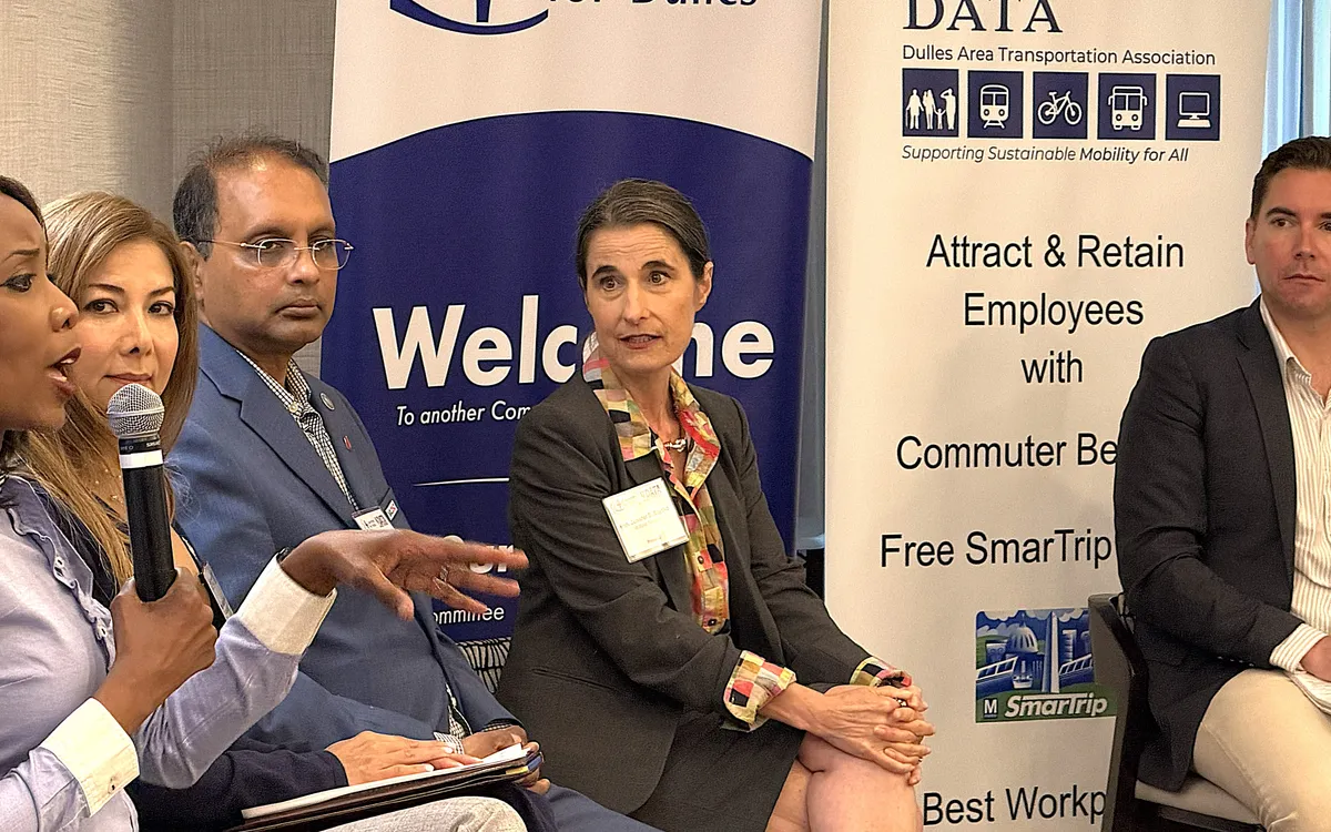 A panel discussion in front of a Dulles Area Transportation Association banner.