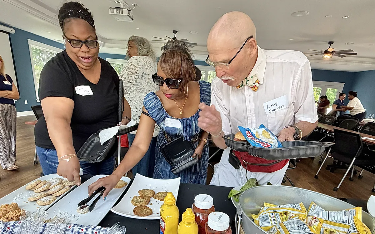 People serving food at a community gathering.